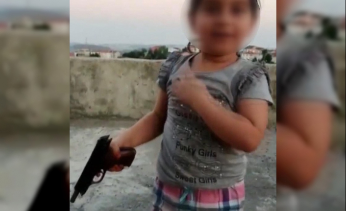 Kız çocuğunun eline silah verip havaya ateş açtırdı