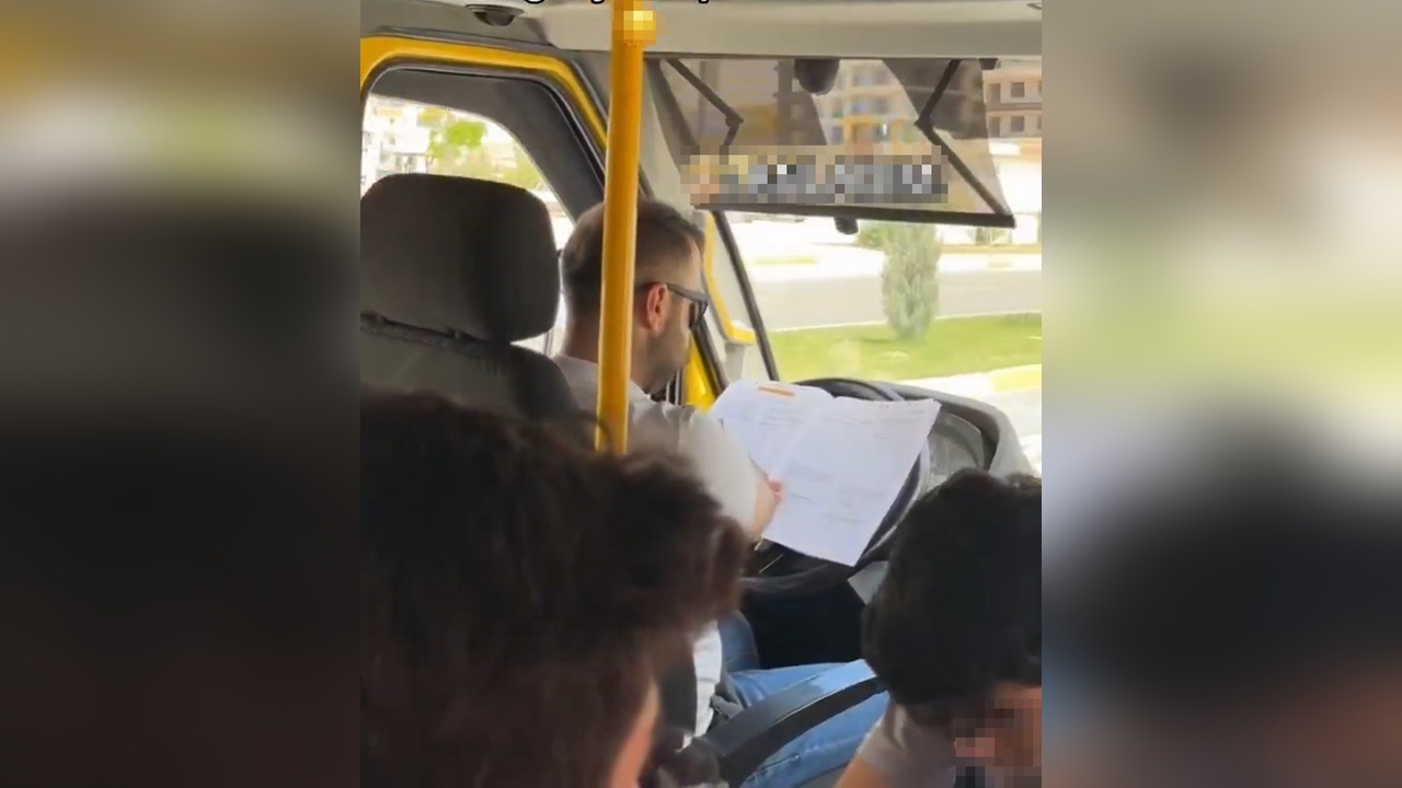 Minibüs şoförü direksiyonda kitap okurken görüntülendi