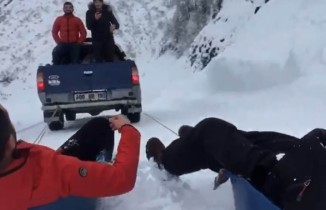 Karda kamyonete bağladıkları leğenle kaydılar